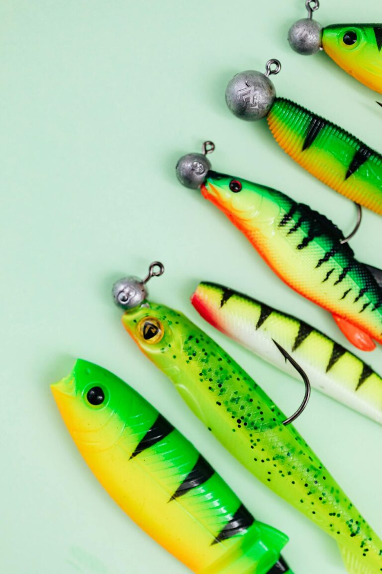 Close-up of colorful fishing lures on a mint green surface, perfect for angling enthusiasts.
